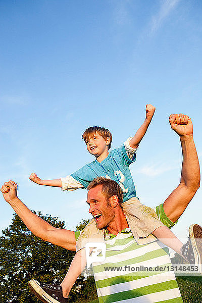 Father With Son on Shoulders Cheering