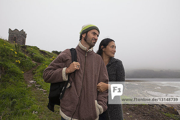 Erwachsenes Paar bei einem Spaziergang an der nebligen Küste  Dingle-Halbinsel  Irland