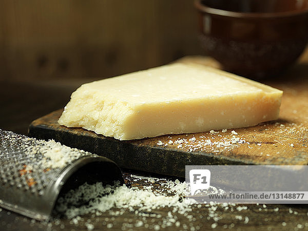 Parmigiano Reggiano cheese  grated on wooden chopping board