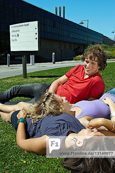 Drei junge Studenten entspannen sich im Gras