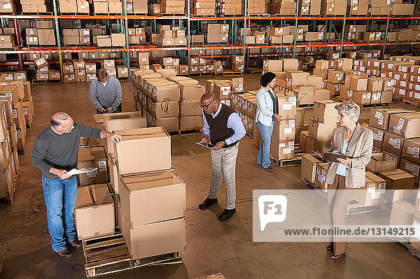 Warehouse workers standing with boxes  high angle