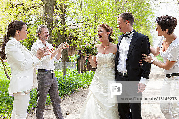 Friends applauding newlywed couple