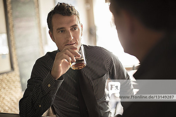 Two businessmen having a drink in wine bar