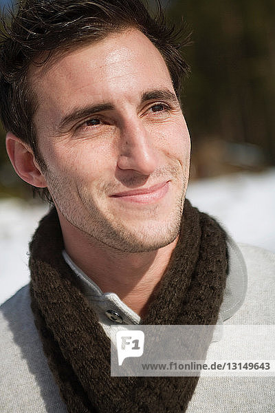 Man outside wearing scarf and smiling