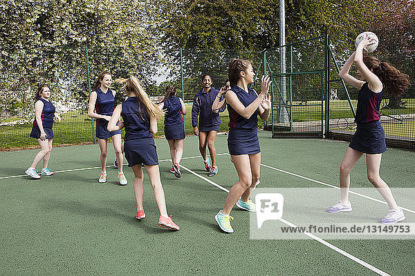 Group of students playing netball in court