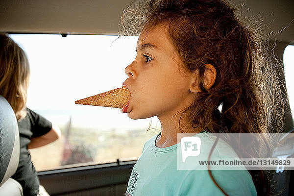 Junges Mädchen mit Eiswaffel im Mund