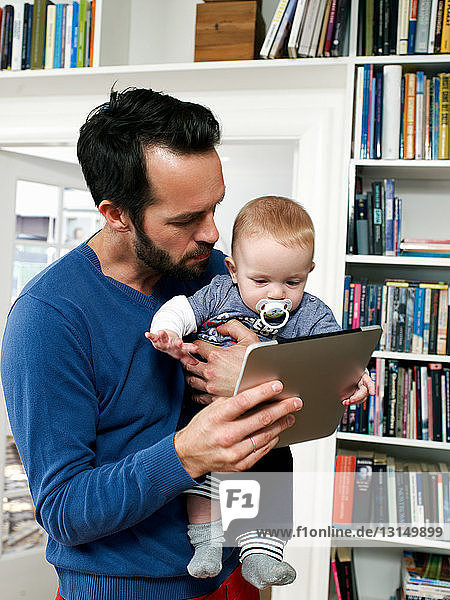 Father showing baby digital tablet