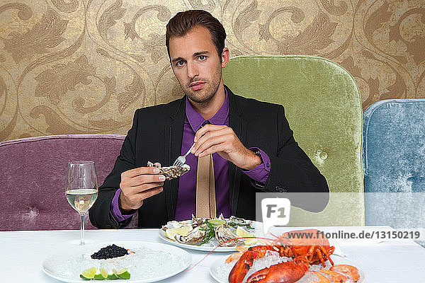 Man eating oysters in restaurant
