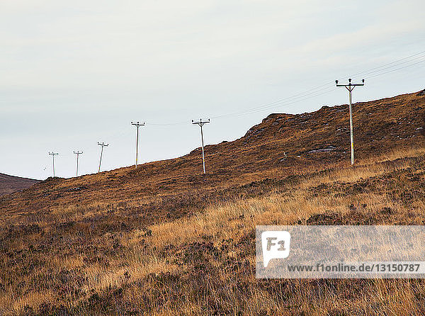 Reihe von Strommasten in abgelegener Landschaft  nordwestliche Highlands  Schottland  UK