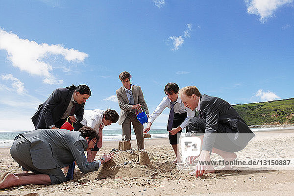 Geschäftsleute bauen eine Sandburg