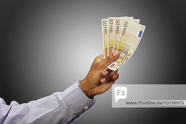 Man holding fanned out euros