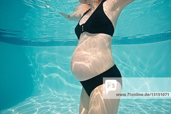 Torso einer schwangeren Frau unter Wasser