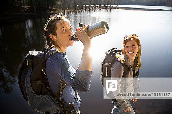 Zwei Frauen teilen sich das Wasser am Ufer eines Sees