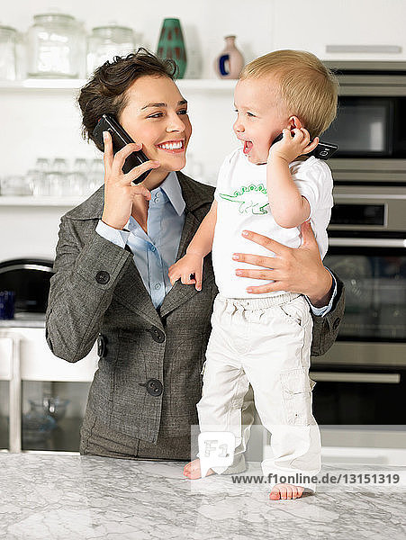 Mutter und kleiner Sohn unterhalten sich am Handy