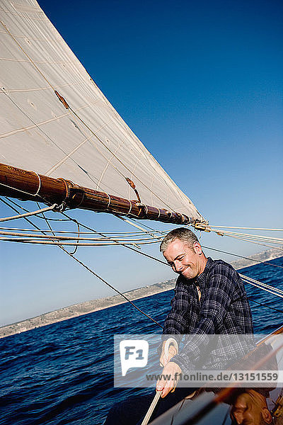 man smiling sitting on a sailing boat