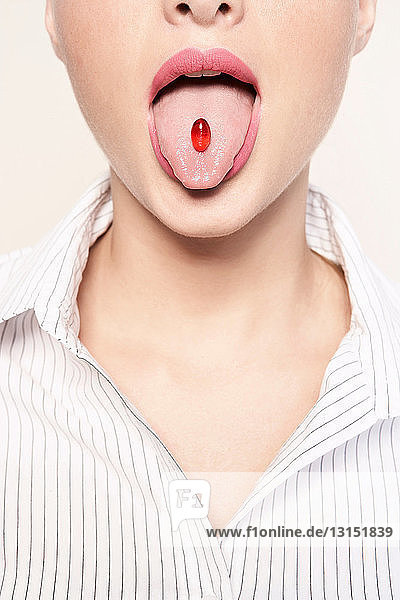 Frau mit Pille im Mund