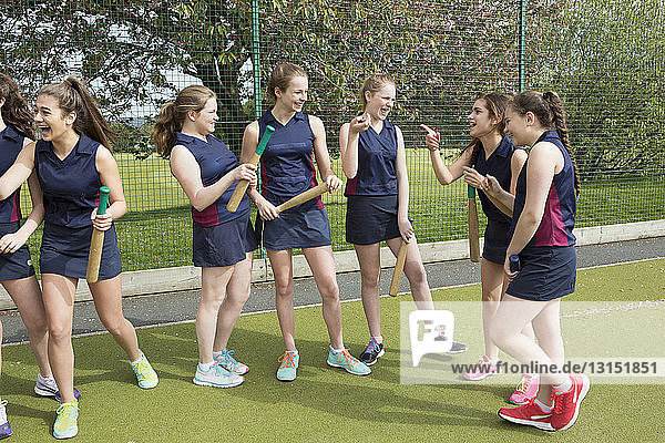 Group of girls on sports fields with rounders bats