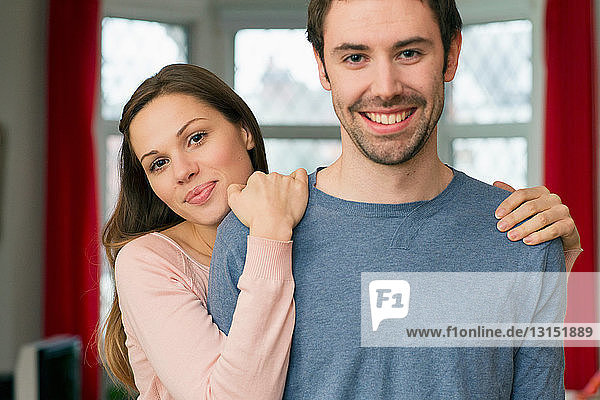 Porträt eines jungen Paares  Frau mit Händen auf den Schultern des Mannes