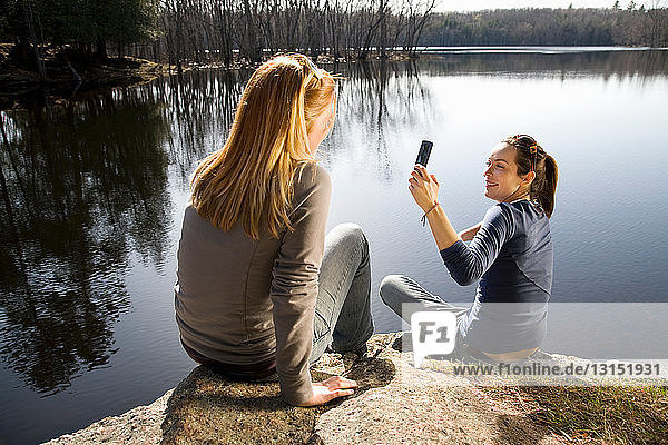 Zwei Frauen fotografieren mit Telefon