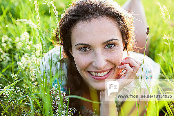 Smiling woman laying in tall grass