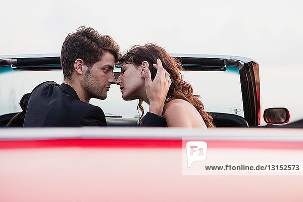 couple in car front seat kissing