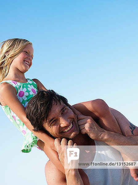 Tochter und Vater spielen am Strand