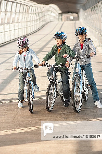 Children riding bicycles in city tunnel