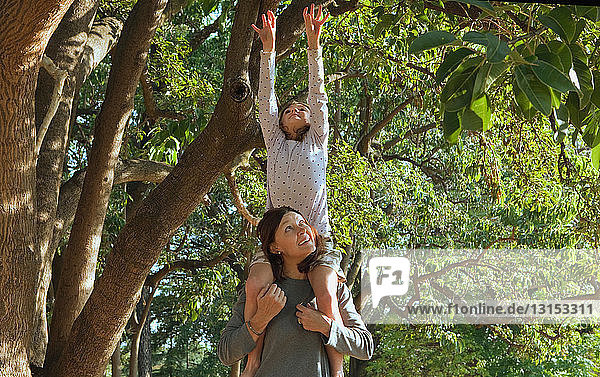 Mother lifting up daughter on shoulders