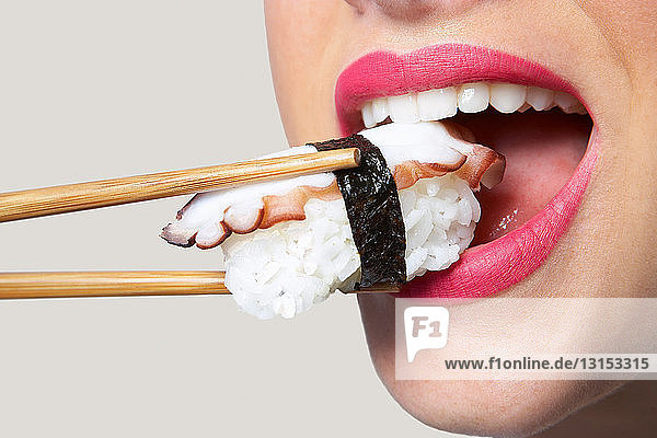 Frau nimmt Sushi in den Mund