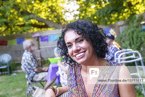 Porträt einer glücklichen jungen Frau auf einer Party im Garten