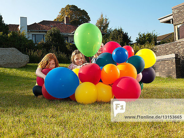 Mädchen hinter bunten Luftballons