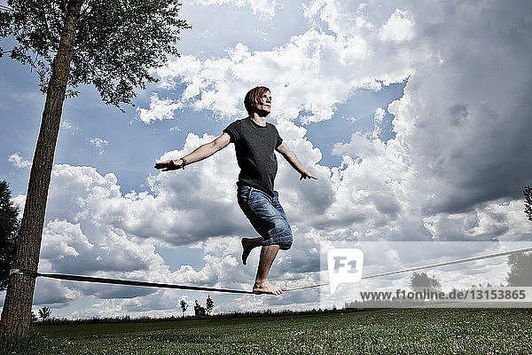Man walking on tightrope outdoors