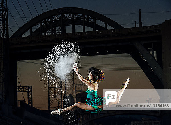 Junge Tänzerin springt  während sie bei Sonnenuntergang eine Pulverexplosion auslöst  Los Angeles  USA