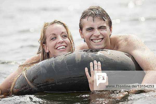 Junges Paar schwimmt in aufblasbarem Ring