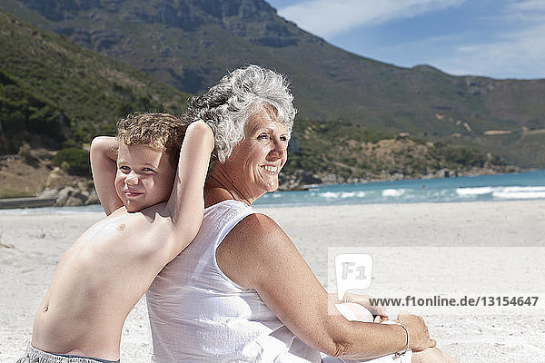 Ältere Frau mit Enkelsohn am Strand