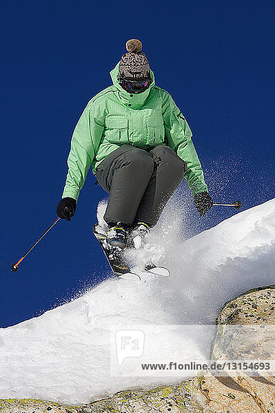 Skier jumping off a rock.