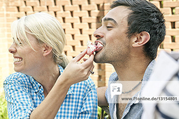 Junges Paar isst Meringues auf einer Gartenparty