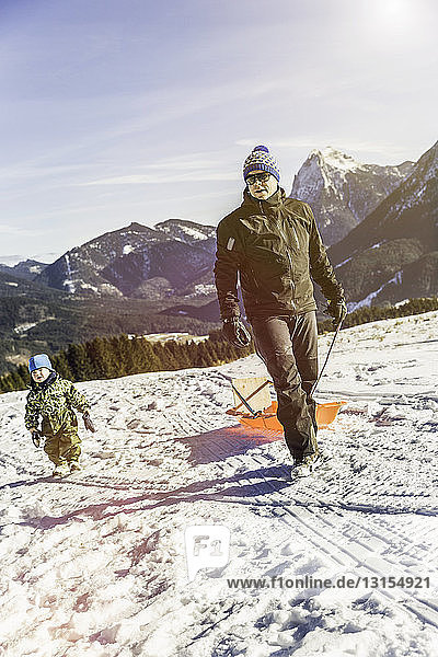 Mann  der einen Schlitten auf Schnee zieht  Achenkirch  Tirol  Österreich