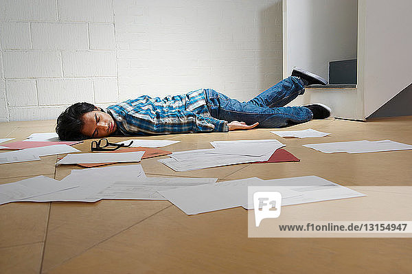 Junger Mann liegt auf dem Boden eines Büros