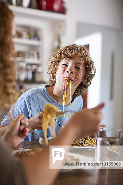 Jugendlicher isst Spaghetti am Esstisch