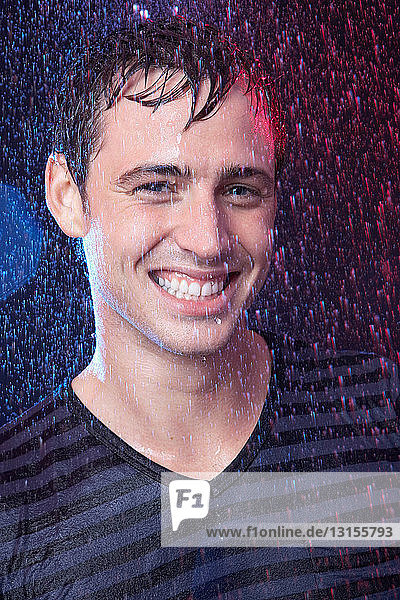 Junger Mann steht im Regen