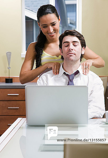 Frau hilft Mann beim Entspannen am Computer