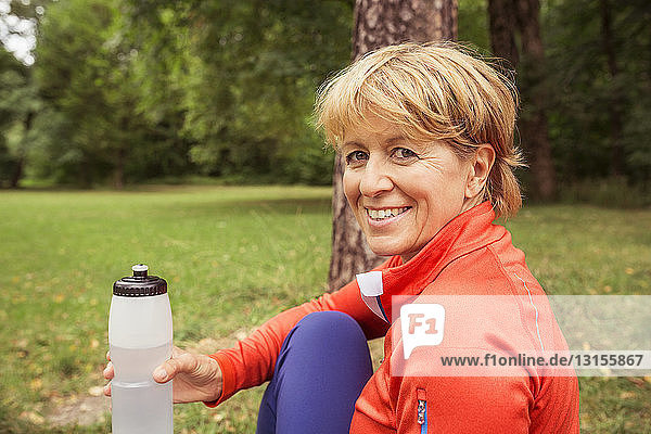 Portrait of mature woman  outdoors  holding water bottle