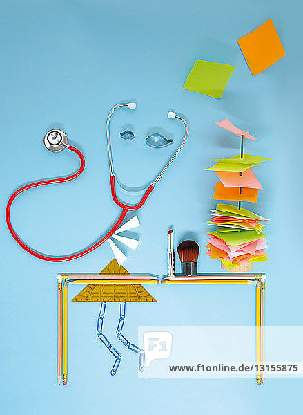 Stethoskop und Schreibwaren vor blauem Hintergrund