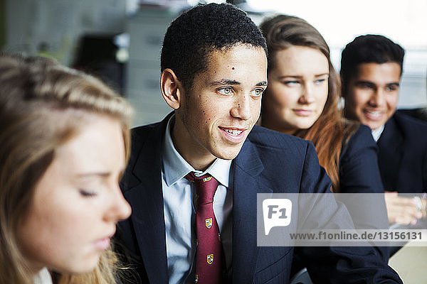Schulkinder im Teenageralter sitzen an den Tischen