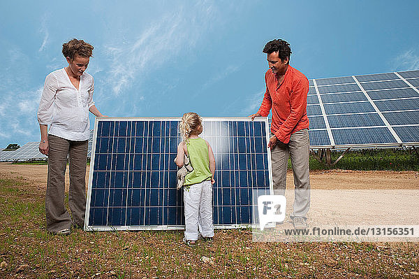 Familie vor einem Sonnenkollektor