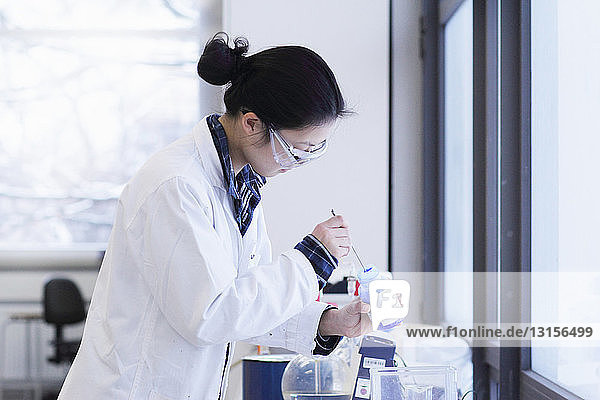 Wissenschaftlerin rührt Flasche im Labor