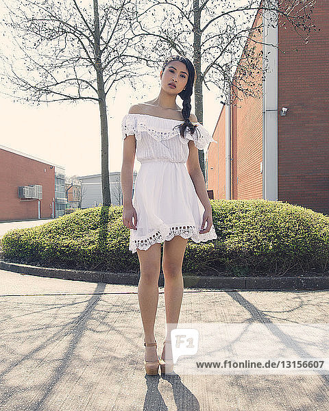 Porträt einer jungen Frau in weißem Kleid  im Freien