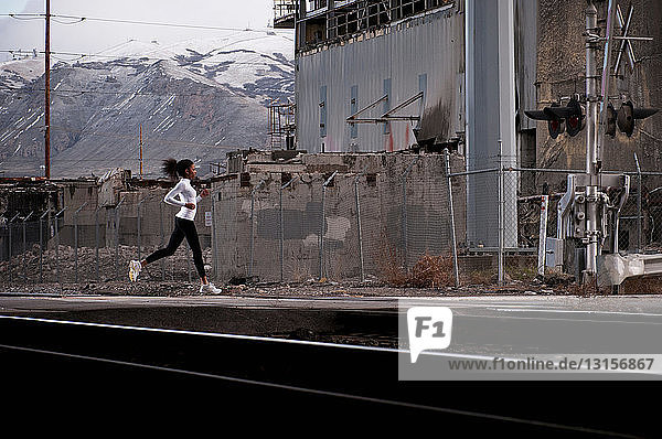 Woman running on industrial city street