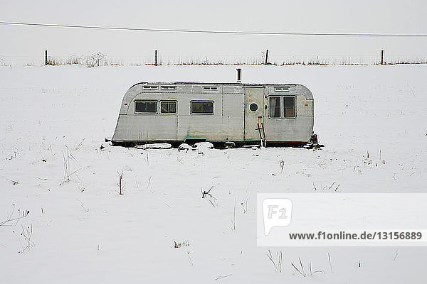 Old trailer in a snowy field